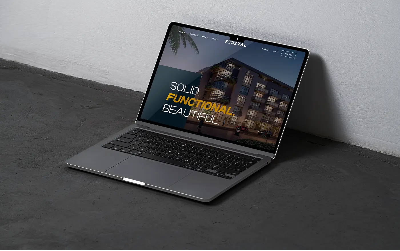 Laptop displaying the Federal homepage hero against a plain wall